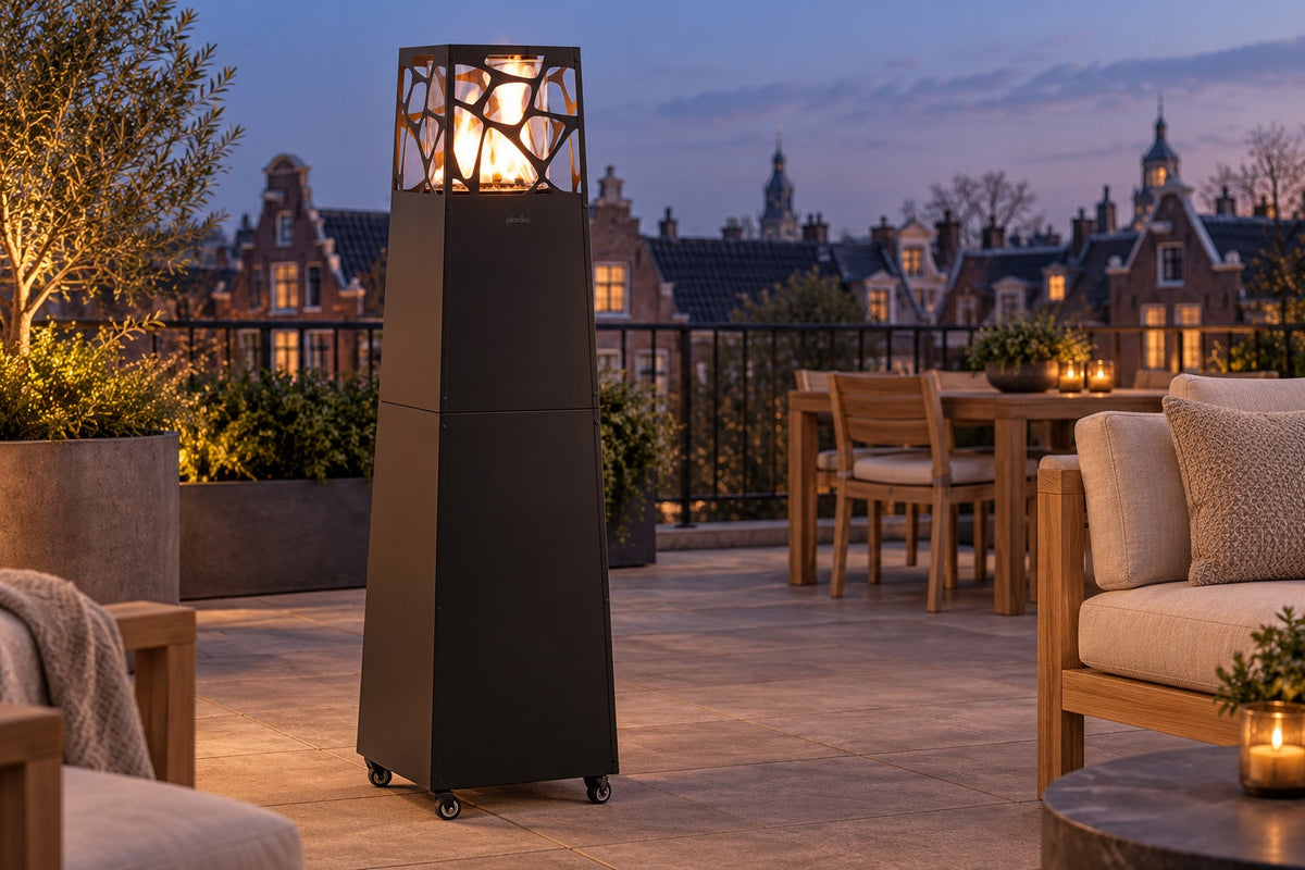 Propane patio heater with a pyramid glass flame tower on a city rooftop terrace at dusk