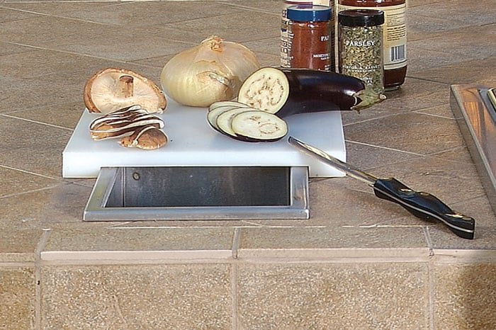 Artisan Professional prep and waste chute in a countertop with cutting board and vegetables
