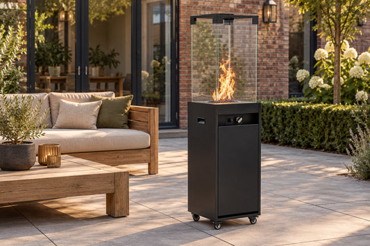 Planika Faro outdoor gas fireplace in black on a backyard patio next to an outdoor sofa